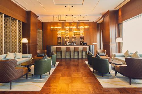 a hotel lobby with chairs and tables and a bar at LJZ Supreme Tower Hotel in Shanghai