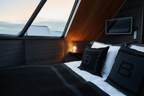 a bedroom with a bed and a window with a tv at Arctic Land Adventure Glass Igloos in Kilpisjärvi