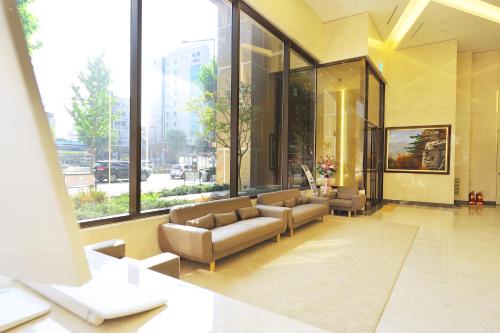 a lobby with couches and windows in a building at The Recenz Dongdaemun Hotel in Seoul