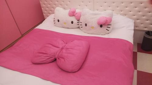 two hello kitty pillows on a bed with pink sheets at Xenia Amagasaki in Amagasaki