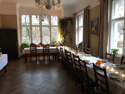 a dining room with a long table and chairs at Pałac Myśliwski Orle in Mirosławiec