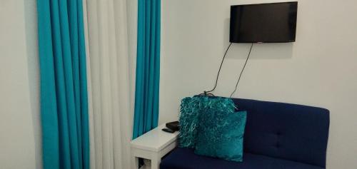 a living room with a blue couch and a television at Retreat Haven in La Bella Tagaytay in Tagaytay