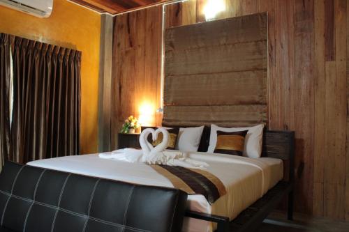 Un dormitorio con una cama con dos cisnes. en BAAN9NAN Home Lodge en Nan