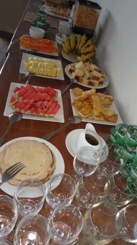 a table with plates of food and glasses of wine at Panorama Green View Hotel Nuwara Eliya in Nuwara Eliya