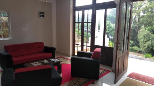 a living room with a red couch and chairs at Panorama Green View Hotel Nuwara Eliya in Nuwara Eliya