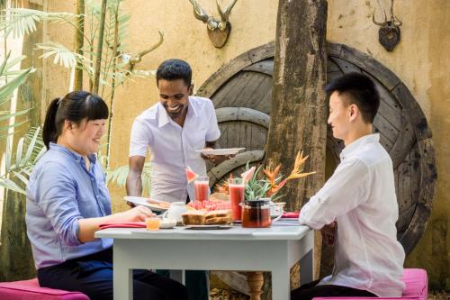 a group of three people sitting around a table at Small House Boutique Guest House in Galle