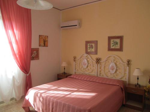 sypialnia z łóżkiem z czerwoną narzutą w obiekcie B&B Alvi w mieście Fertilia