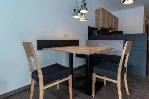 a kitchen with a wooden table and two chairs at A CASA Rubin Chalet & Studio Resort in Sölden