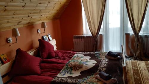 a bedroom with a bed with red pillows at Эдельвейс in Tsaghkadzor