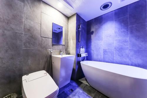 a bathroom with a tub and a toilet and a sink at Seosan Aria Hotel in Seosan