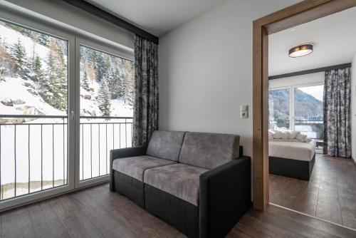 a living room with a couch and large windows at A CASA Rubin Chalet & Studio Resort in Sölden