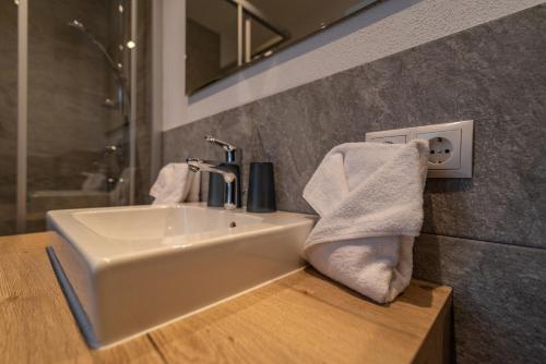 a bathroom sink with a towel on a wooden counter at A CASA Rubin Chalet & Studio Resort in Sölden
