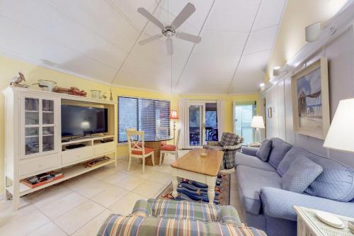 a living room with a blue couch and a tv at Night Heron 35 in Hilton Head Island