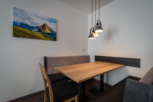 a dining room with a wooden table and chairs at A CASA Rubin Chalet & Studio Resort in Sölden