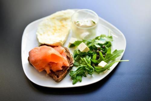 a plate of food with a sandwich and a salad at Legado Alcazar Hotel in Seville