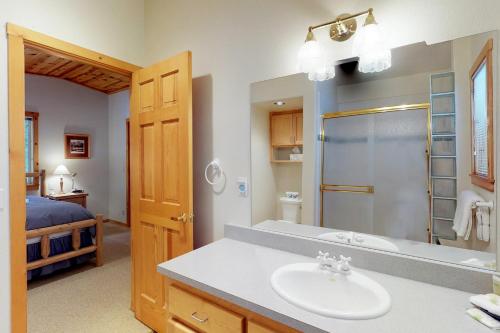 a bathroom with a sink and a shower and a bed at Happy Family Cozy Cabin in Truckee