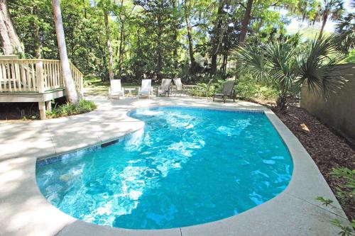 a swimming pool with blue water in a yard at Eagle Watch in Hilton Head Island