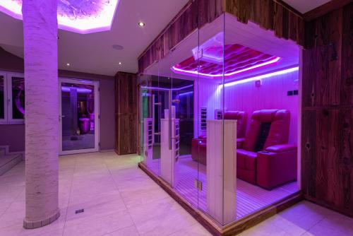 a room with purple lights and a room with chairs at A CASA Rubin Chalet & Studio Resort in Sölden
