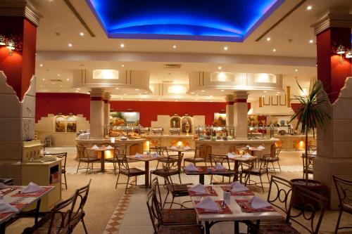 a restaurant with tables and chairs and a bar at Hurghada Coral Beach Hotel in Hurghada