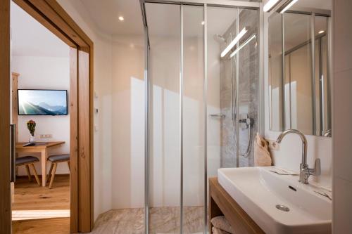 ein Badezimmer mit Glasdusche und Waschbecken in der Unterkunft Appartementhaus Adlerblick in Mayrhofen
