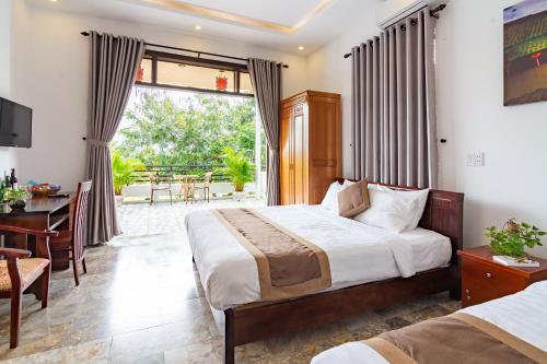 a hotel room with a bed and a desk and a window at Horizon 2 villa in Hoi An
