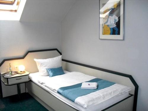 - une chambre avec un lit, une table de chevet et une photo dans l'établissement Donatus Hotel, à Brauweiler