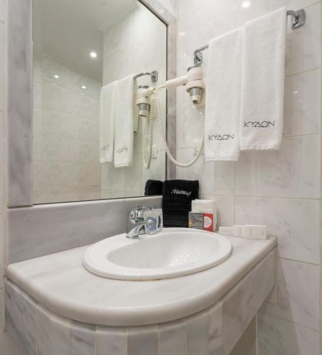 a bathroom with a sink and a mirror and towels at Kydon The Heart City Hotel in Chania Town