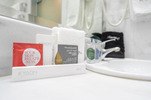 a bathroom counter with toiletries and a sink at Kydon The Heart City Hotel in Chania Town