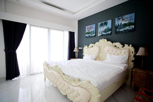 a bedroom with a white bed with a white bedspread at Vanilla Suite Jimbaran in Jimbaran