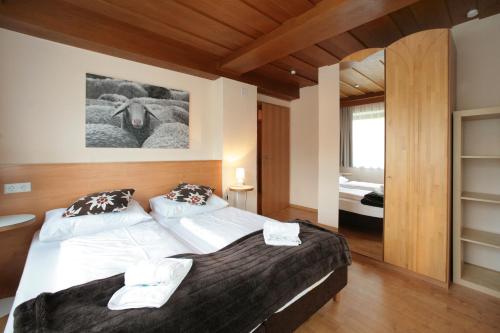 a bedroom with a large bed with white sheets at Edelweiss am See in Zell am See