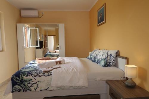 a small bedroom with a bed with a mirror at Apartments Leon Nin in Nin