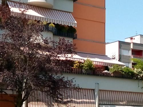 un edificio con un balcón con plantas. en B&B Metrò, en Bussero