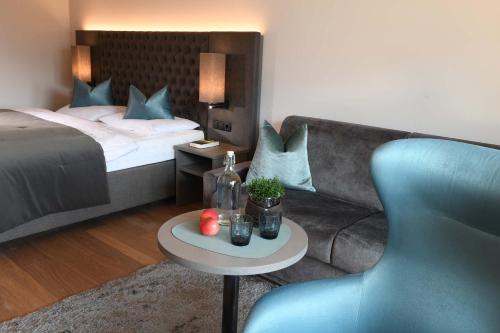a bedroom with a bed and a couch and a table at Hotel Das Stachelburg in Parcines