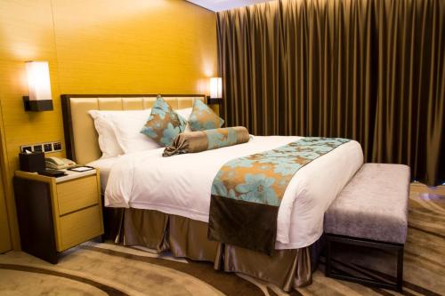 a hotel room with a bed and a phone at Shenzhen Futian Wyndham Grand in Shenzhen