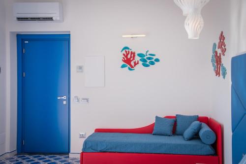 a room with a red and blue couch and a blue door at Palazzo San Giovanni Amalfi Coast in Scala