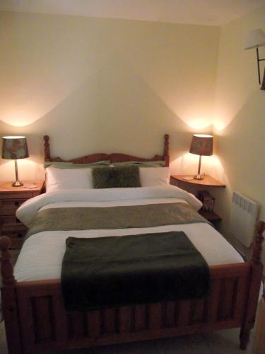 une chambre avec un grand lit avec deux lampes dans l'établissement The Lodge, à Les Dognons