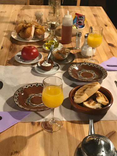 a table with plates of food and glasses of orange juice at Casa Rural Valle del Arrago in Robledillo de Gata