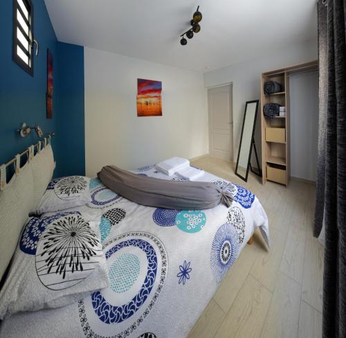 a bedroom with a bed with a blue and white blanket at LE BELVÉDÈRE in LʼEntre-Deux