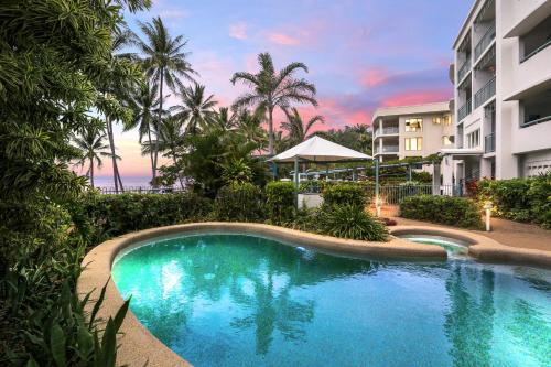 a swimming pool in front of a building at Trinity Waters Boutique Beachfront in Trinity Beach