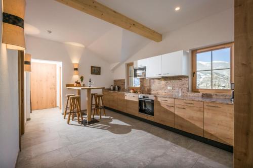 eine Küche mit Holzschränken und einem Tisch darin in der Unterkunft Appartementhaus Adlerblick in Mayrhofen