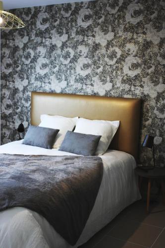 - une chambre avec un grand lit et du papier peint floral dans l'établissement Clos de la Couturelle, à Millonfosse