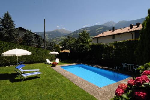 a swimming pool in the yard of a house at Appartments Innerhofer in Rifiano