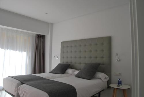 a bedroom with two beds and a large window at Estudiotel Alicante in Alicante