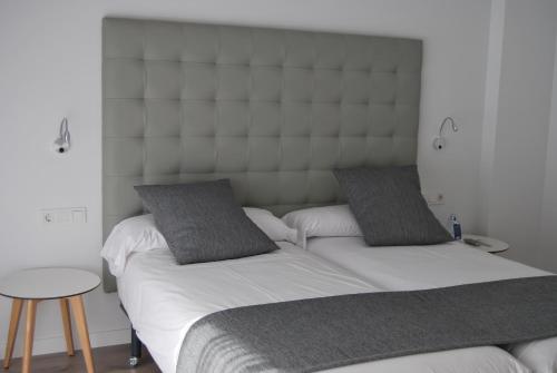 two twin beds in a bedroom with a headboard at Estudiotel Alicante in Alicante