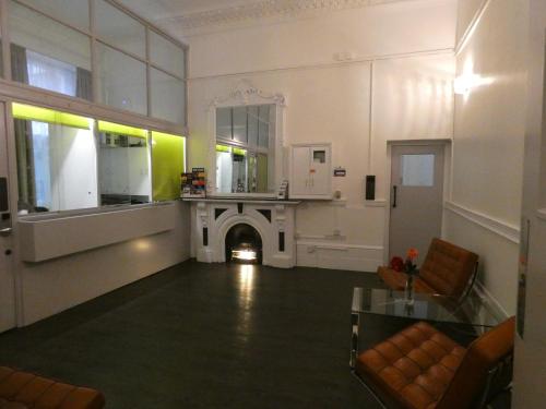 a living room with a fireplace and a mirror at New Mansion House (Lancaster Gate) in London