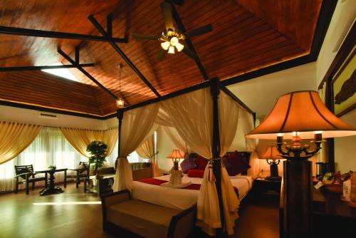 a bedroom with a canopy bed with a ceiling fan at Wild Planet Jungle Resort in Devāla
