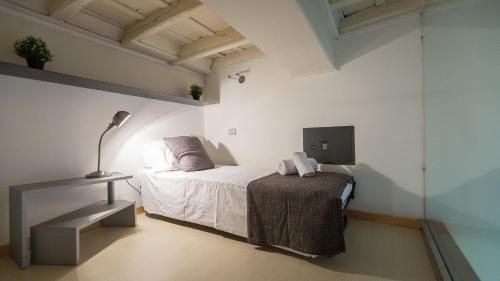 ローマにあるRental in Rome Purificazione apartamentの白いベッドルーム(ベッド1台、ランプ付)