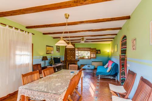 a dining room and living room with a table and chairs at Casa Rural Valle del Arrago in Robledillo de Gata