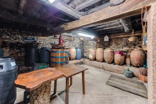 a room with a table and some wine barrels at Casa Rural Valle del Arrago in Robledillo de Gata