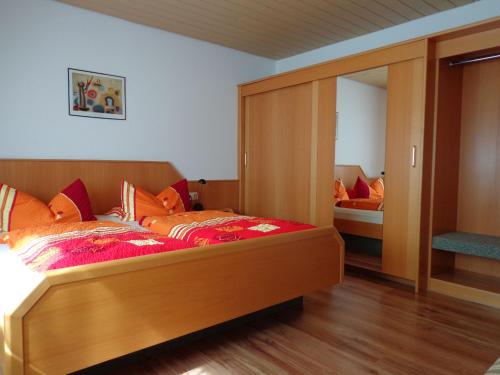 a bedroom with a large wooden bed and a mirror at Haus am Weinberg in Endingen